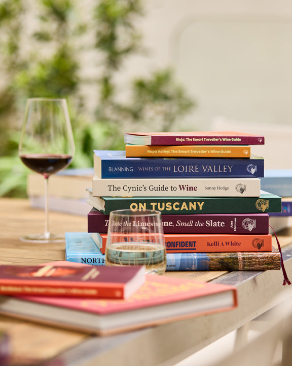 Wine books are lying on the table with 2 glasses of wine on a summer day
