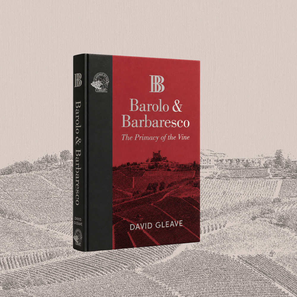 A hardcover book titled "Barolo & Barbaresco: The Primary of the Vine" by David Gleave, shown standing upright against a beige textured background with a faded grayscale vineyard illustration. The cover is predominantly red with a black spine and white text.