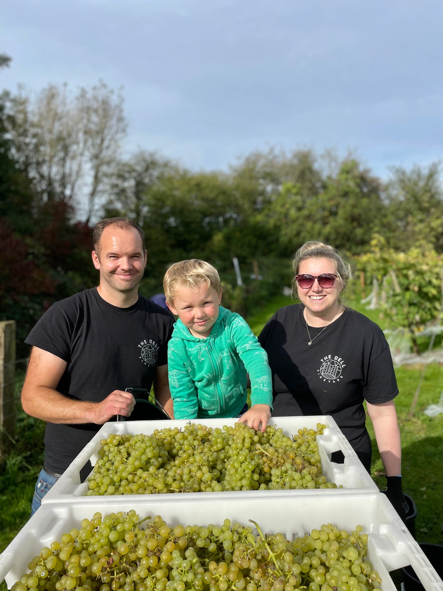 Dan and Lucy Alder with their son Rowan at The Dell Vineyard with produce