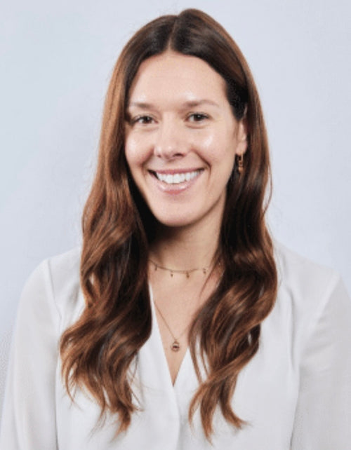 Georgia Hindle sits and smiles at the camera in a white background
