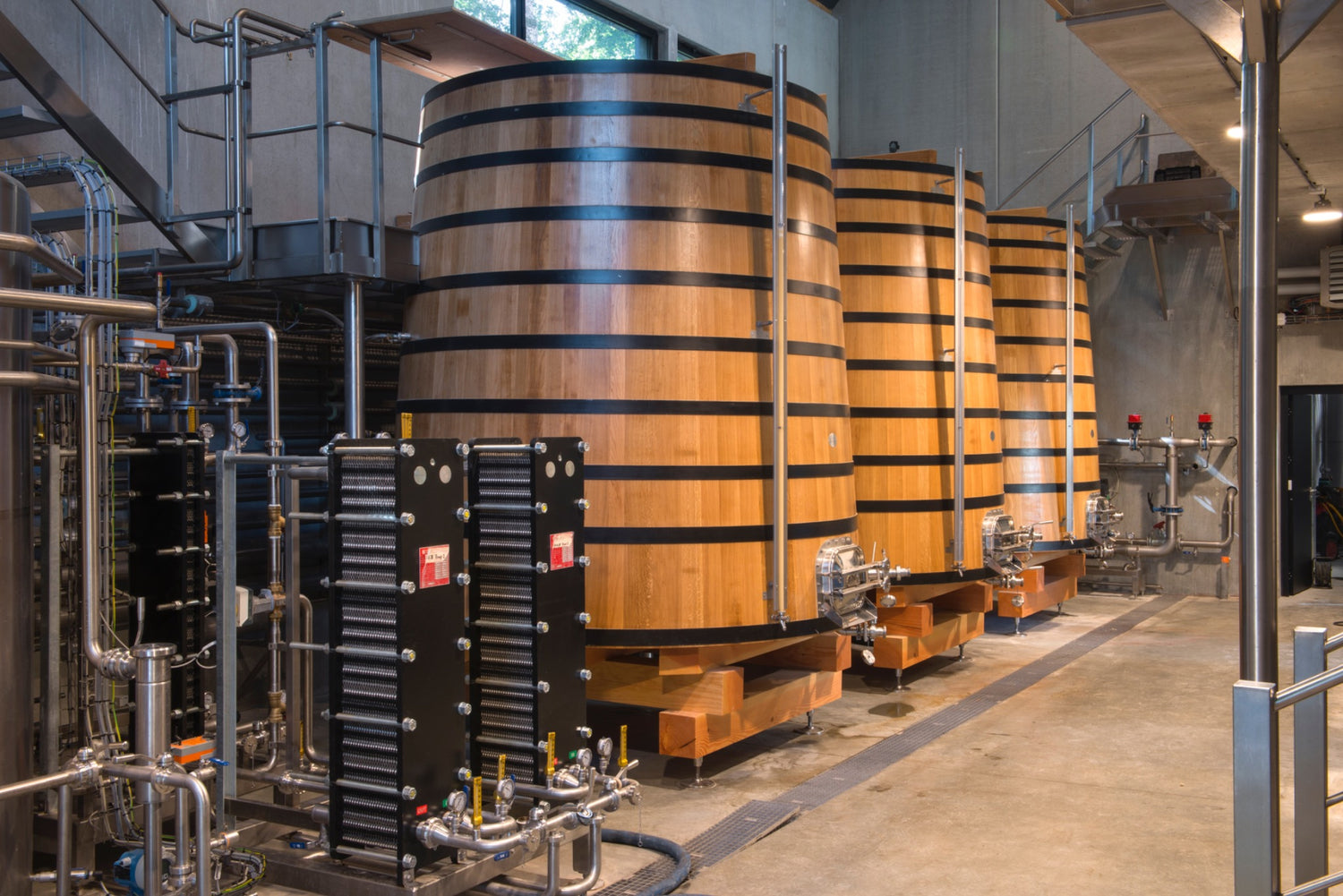 The interior of a distillery with large striped barrels, and machinery