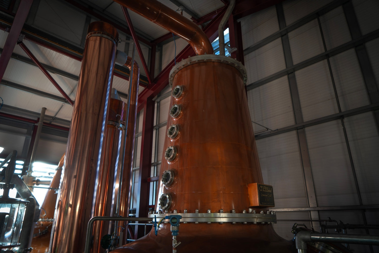 The interior of the distillery with large copper pipes