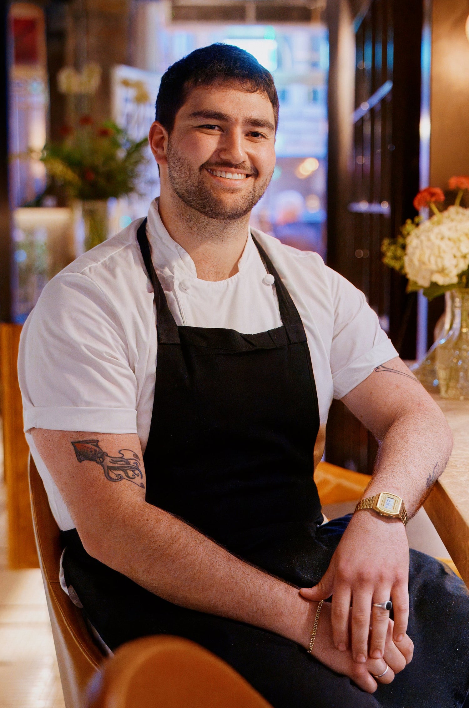 Jack Godik sits at a counter, smiling towards the camera.