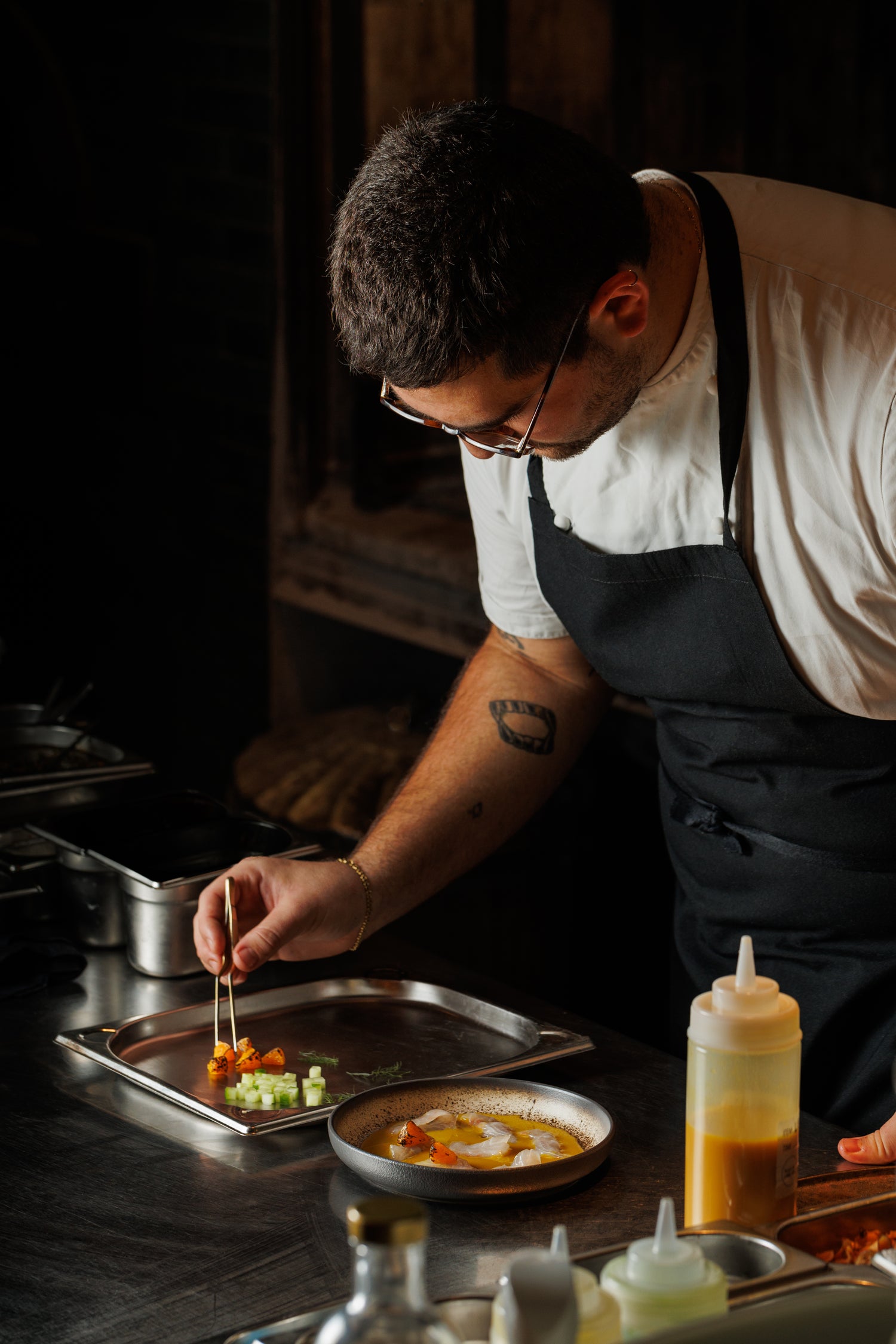 Jack Godik is finishing plating a dish.
