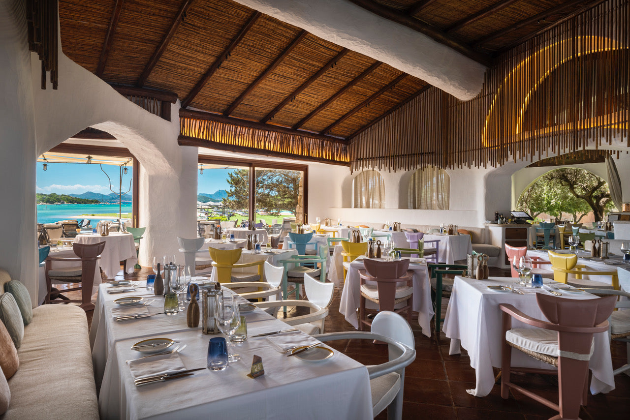 The inside of a restaurant dining area with a tropical backdrop.